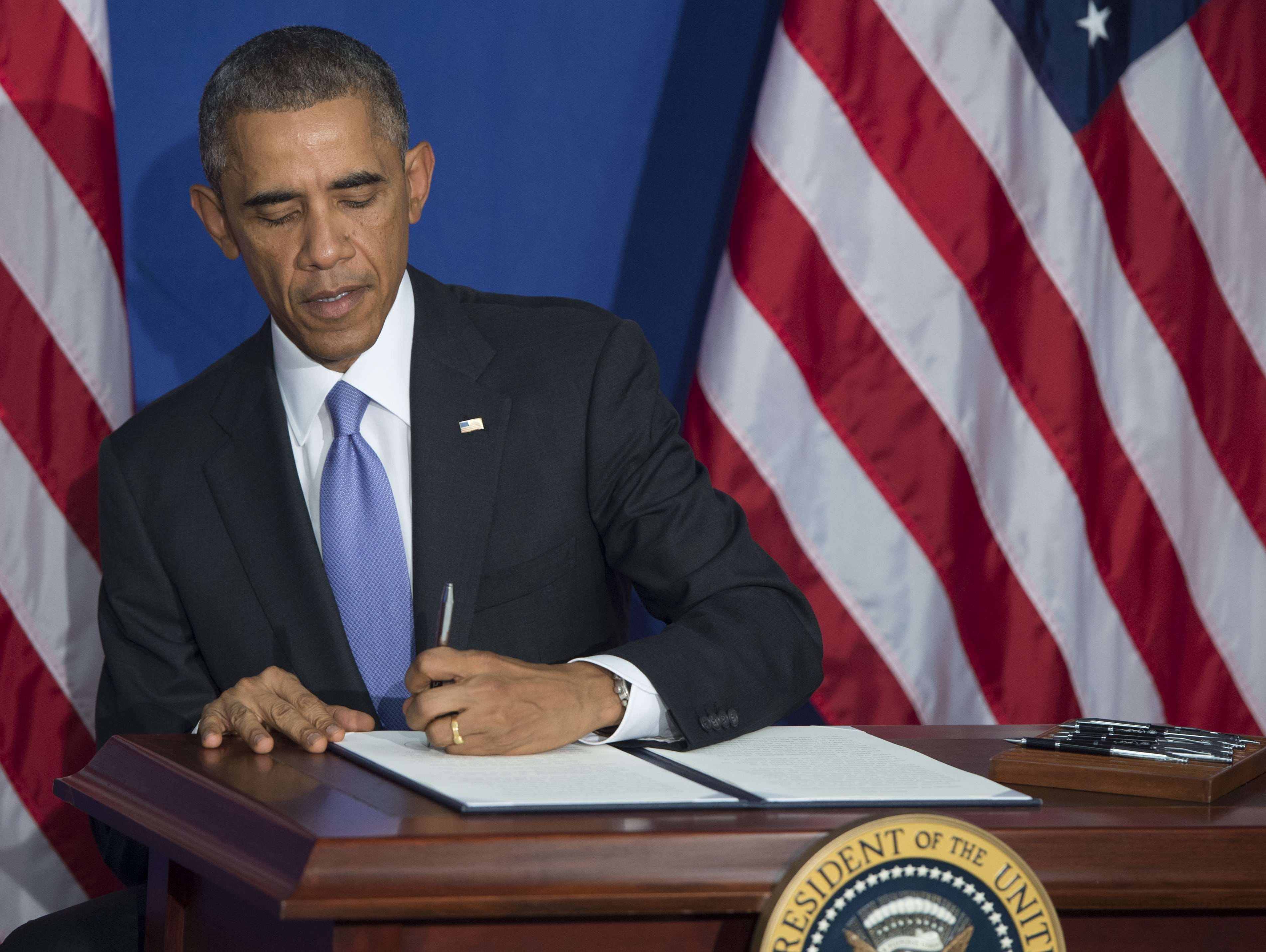 President Obama signs an Executive Order to implement enhanced security measures on consumers' financial security following remarks at the Consumer Financial Protection Bureau (CFPB) in Washington, DC, October 17, 2014. The measures include plans to 