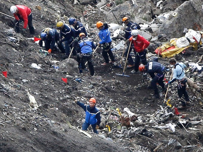 Rescue workers look over debris from the Germanwings