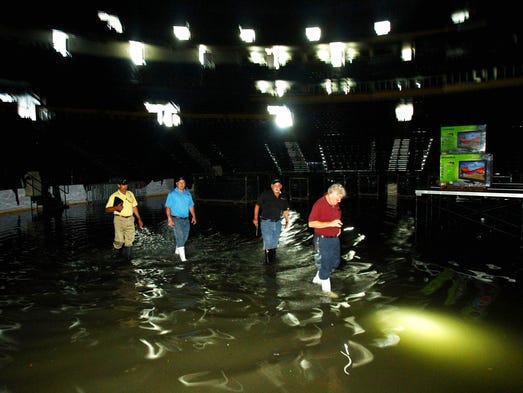 Workers and contractors survey the rising floodwaters