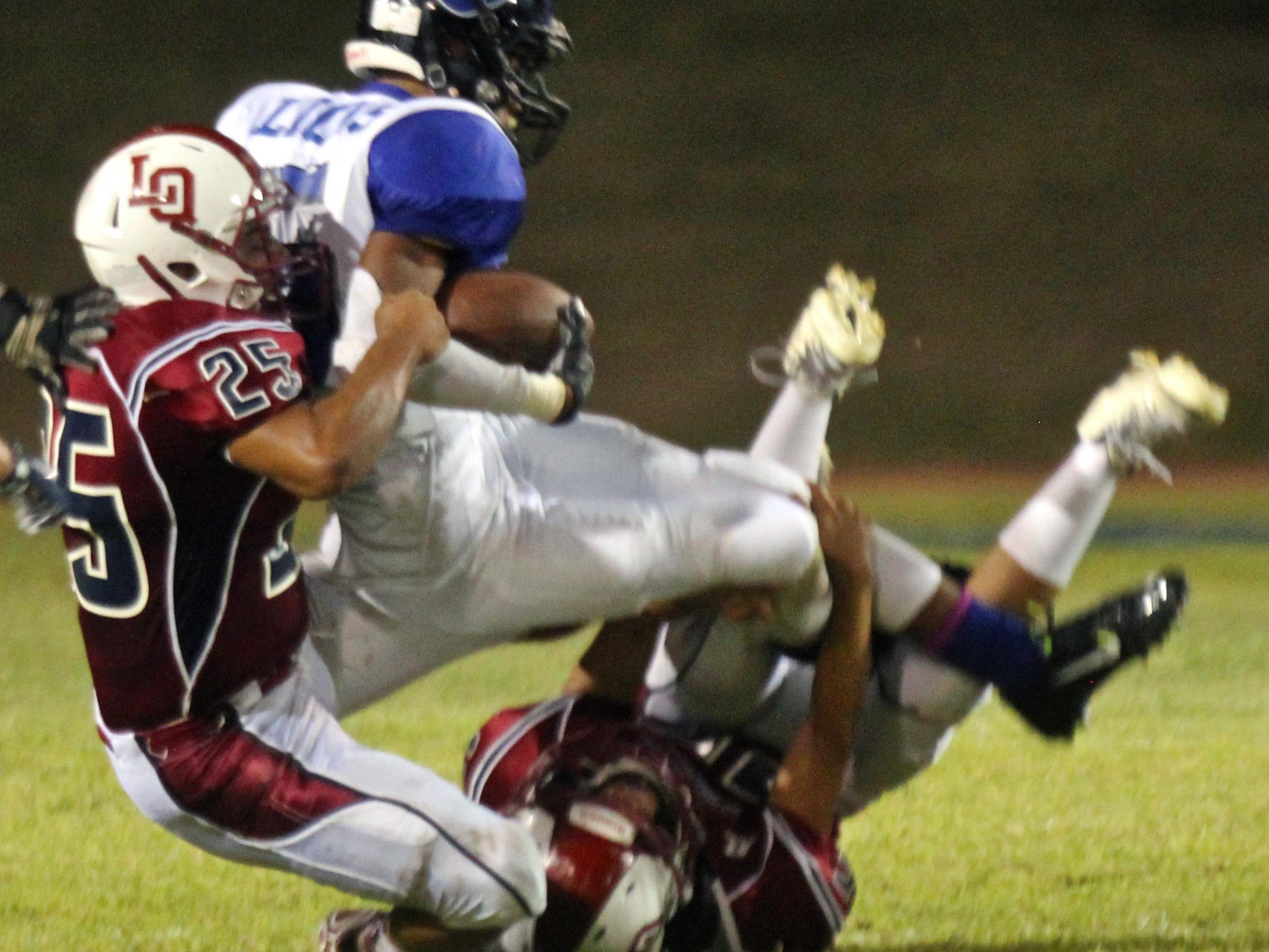 Blackhawks’ Gary Robles (25) tackles a Lions offensive player during a home game on Friday.