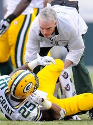 Green Bay Packers running back Ryan Grant (25) is assisted