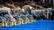 Ryan Lochte, center, dives in the pool at the start