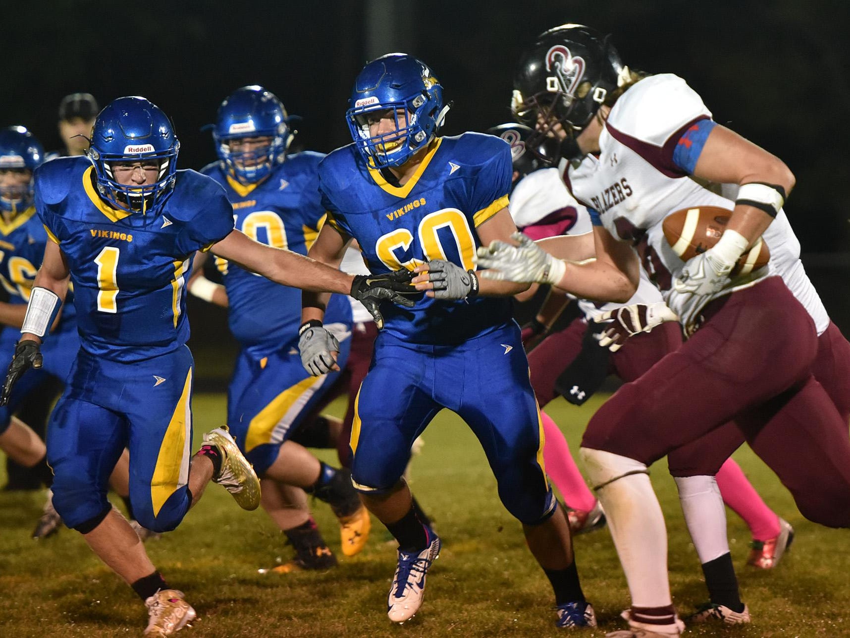 Gibraltar’s Logan Ferry (1) and Nathan Ewaskowitz (60) attempt to get to N.E.W. Lutheran running back Gabe Lloyd during the 8-man football game Friday night. NEW moved to 8-0 with a 42-24 win.