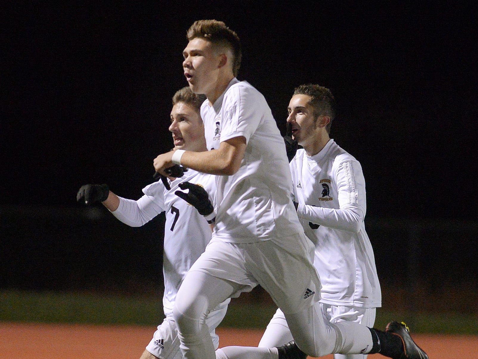 Greece Athena's CJ Takatch, left, celebrates his first half goal with teammates Nick Visca and Matt Palermo during the Section V Class A1 final played at Hilton High School on Oct. 28, 2016.