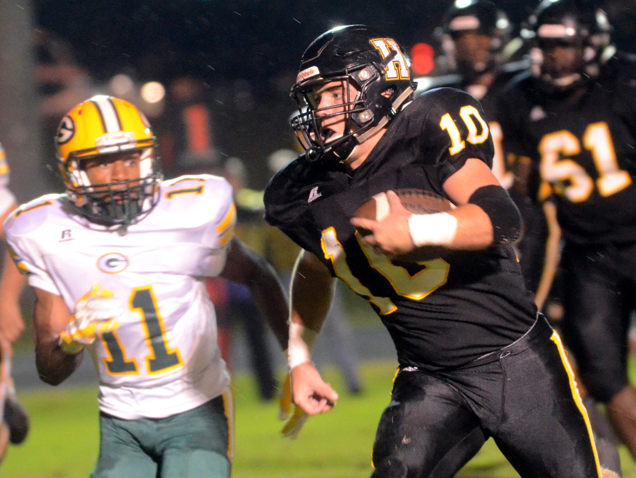 Hendersonville High senior Jack Towe carries the football to the end zone during a 14-yard touchdown run in the second quarter as Gallatin junior Dezmond Chambers pursues.