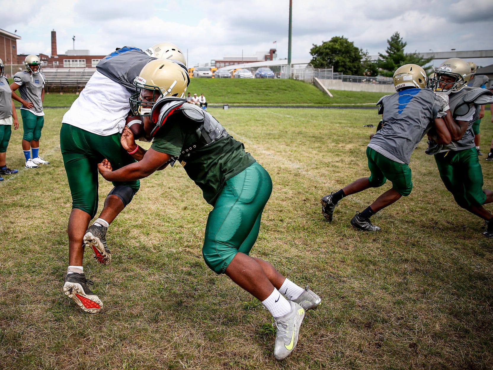 Crispus Attucks Tigers players work on tackling during a drill during practice at Alonzo Watford Athletic Field on Aug. 17, 2016.