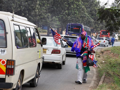 A Kenyan vendor sells American and Kenyan flags, in