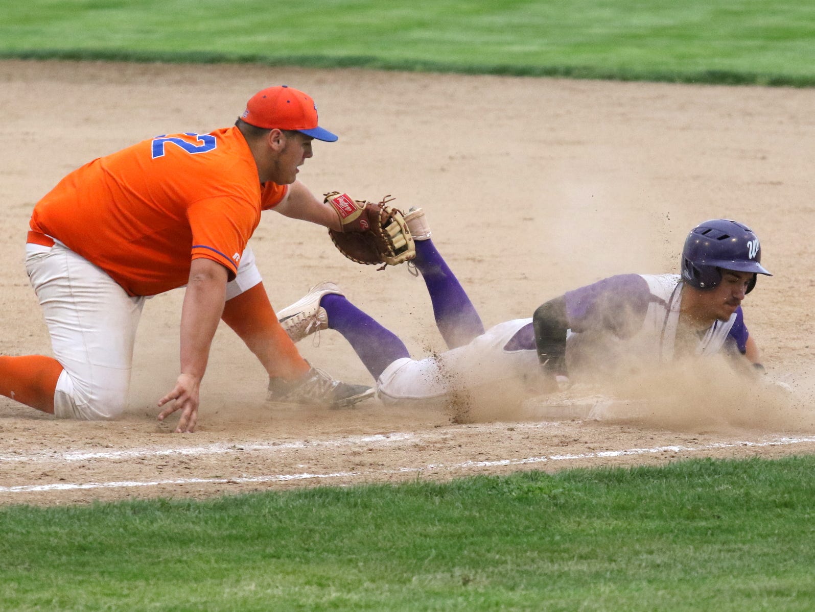 Skyler Jennings of Union Springs dives back to first safely as Edison's Kieran Goodwin tags his foot during Friday's IAC Large School title game at Dunn Field.