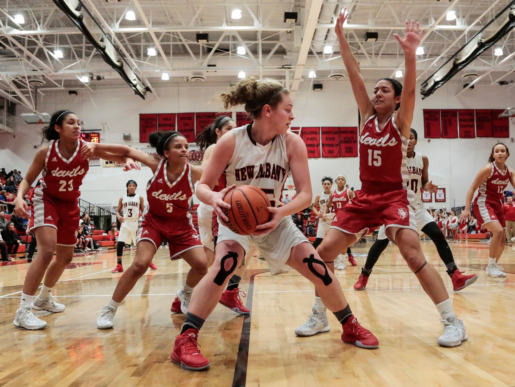 New Albany's Marissa Jones (23) looks to pass while heavily guarded by a swarm of Jeffersonville Devils during the second half of play, Wednesday, Jan. 27, 2016, at New Albany High School in New Albany, In.