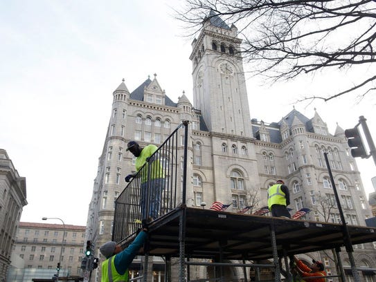 Workers build staging in front of the Trump International