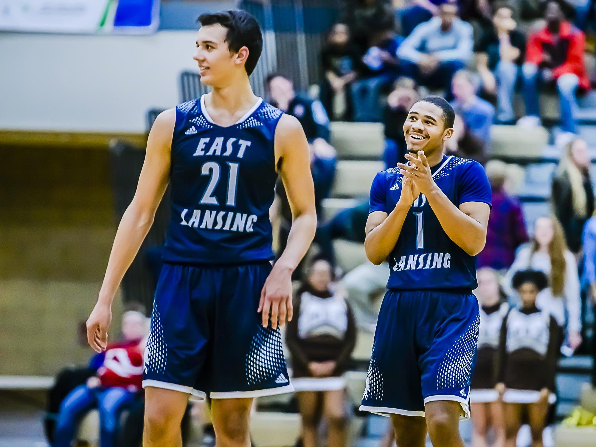 BJ Powell ,1, of East Lansing and teammate Westin Myles ,21, of East Lansing celebrate after a Holt turnover with less then a minute remaining in their game Friday January 15, 2016 in Holt. East Lansing consolidated their lead in the last minutes of the game to win 54-48.