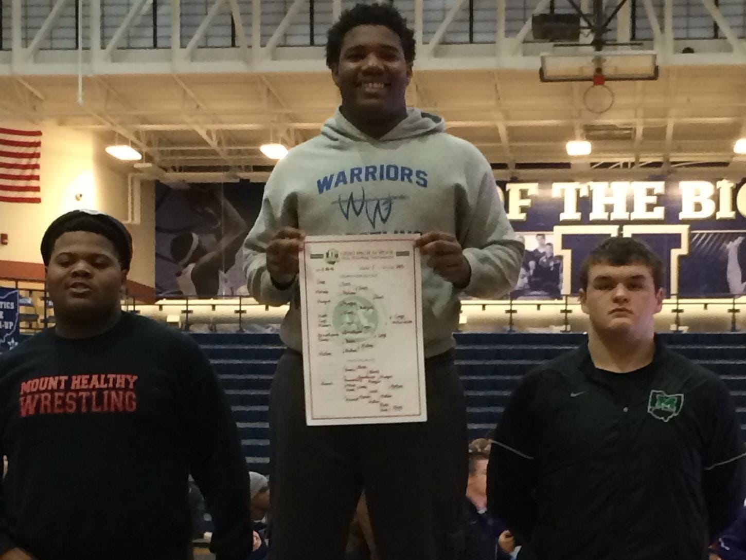 Winton Woods’ Jerron Cage holds up the Division I sectional bracket he won last season at 285 pounds.