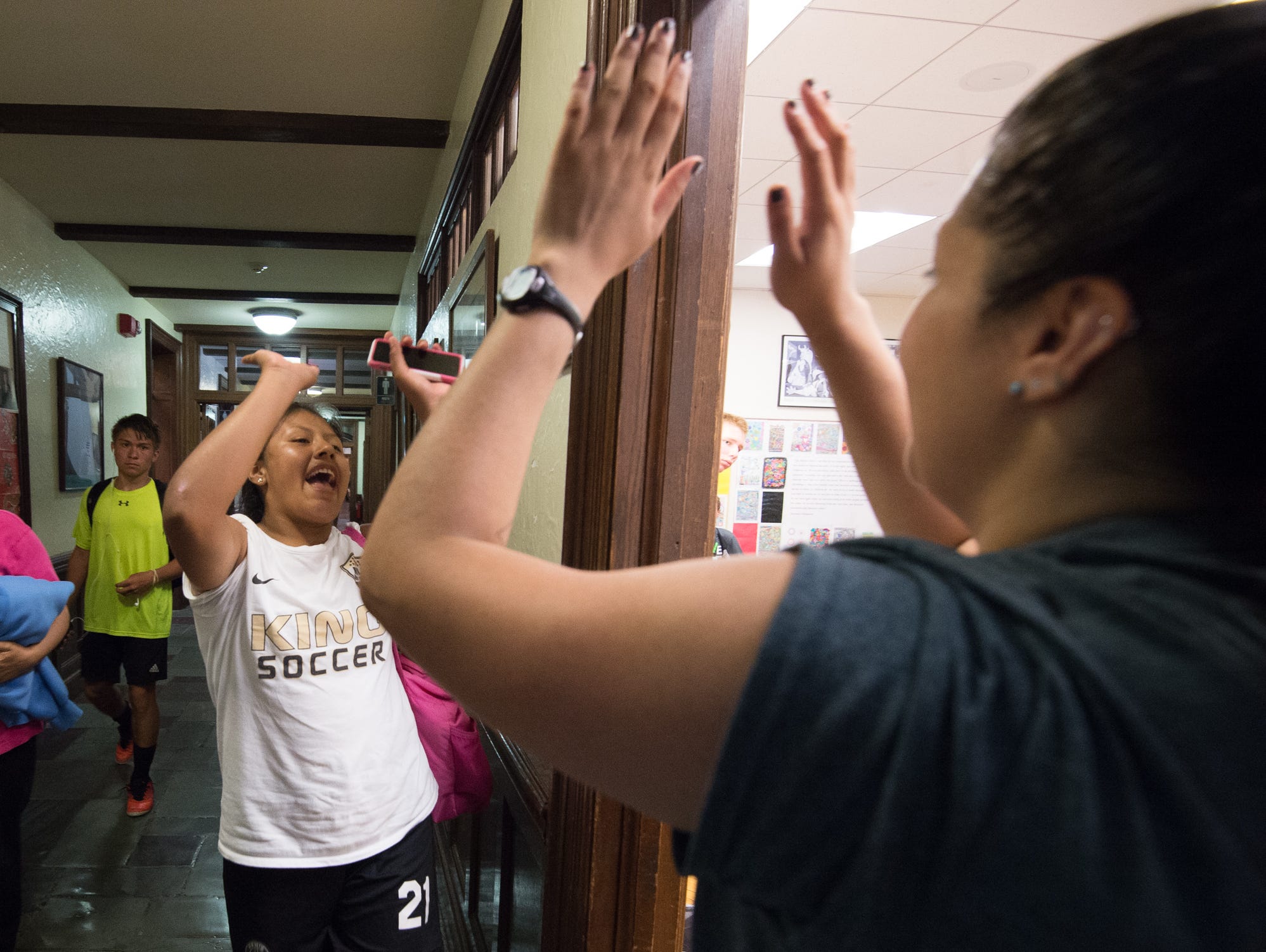 Mechelle Perez, left of Queens, N.Y., receives a high five from Strive Sports Challenge director, Sabrina Zurkuhlen, before a classroom instruction session at the Strive Sports Challenge at St. Andrew's School in Middletown, Del,.