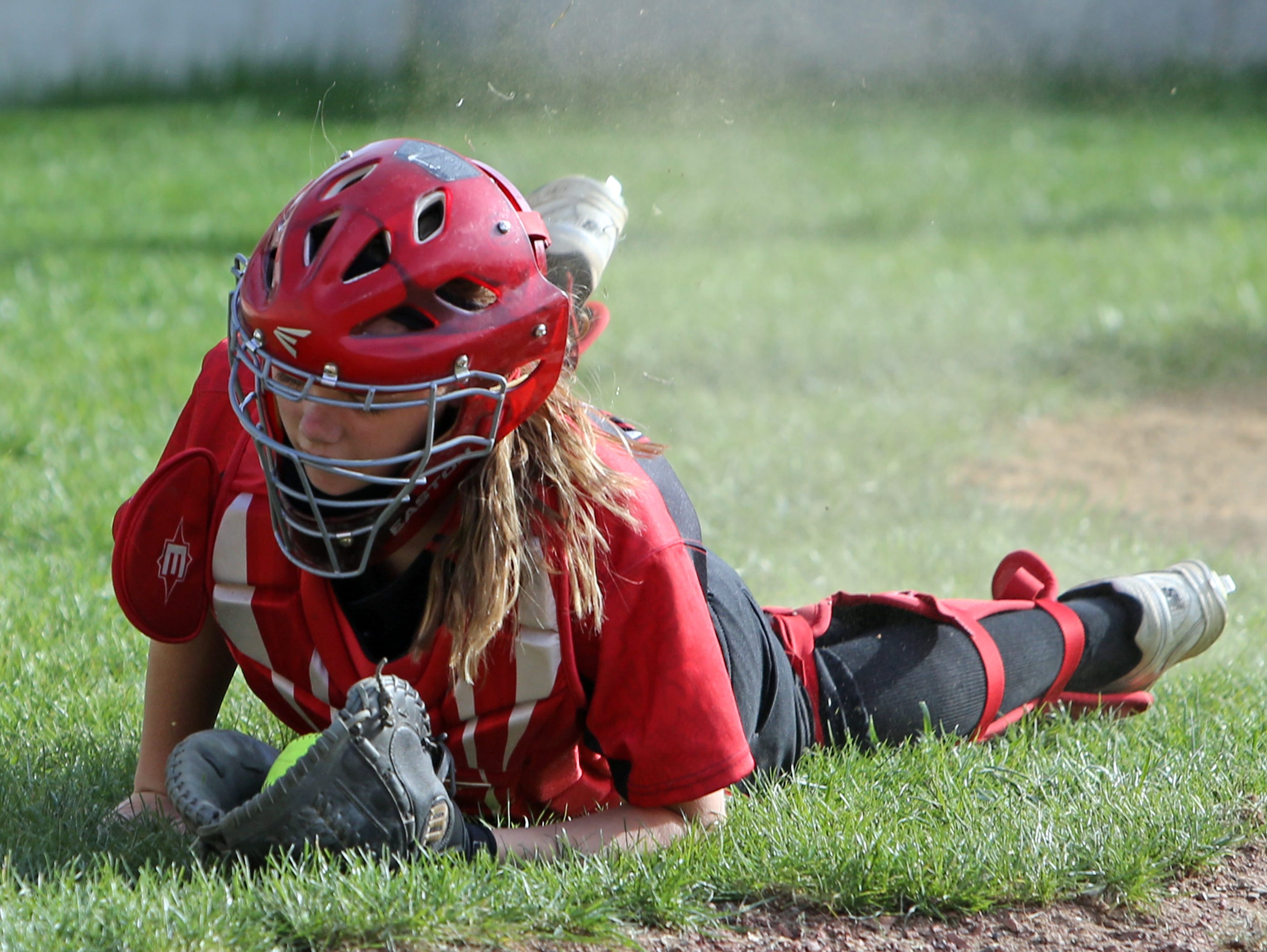 Milford Catcher Kelsey Seitz makes a diving catch of a pop foul.