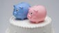 The average cost of a wedding cake in 2013 was $546, TheKnot.com says. Piggy banks top this wedding cake, accurately depicting the effect the cake has on a wedding budget.