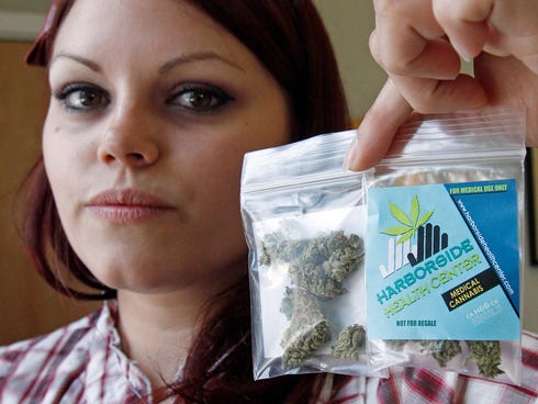 Dani Geen holds a 1 1/2 gram 'care packages' of medical marijuana at the Harborside Health Center in Oakland, Calif.