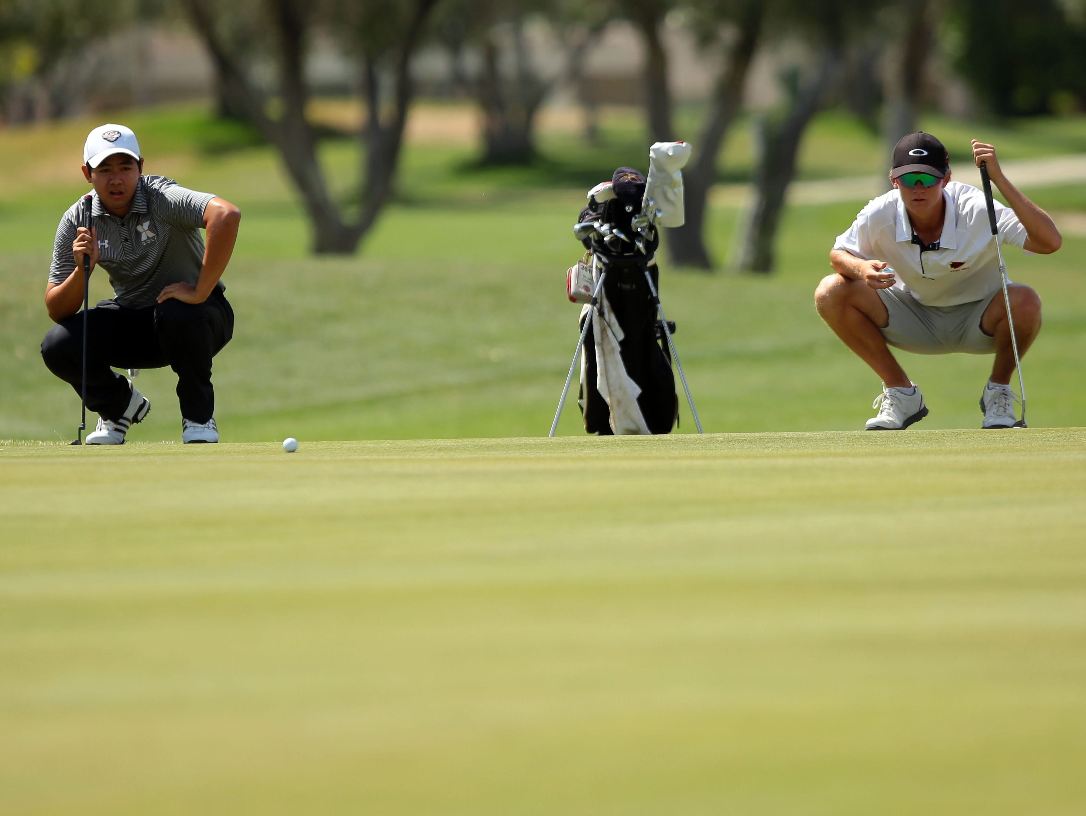 Xavier's Shawn Tsai (left) and Palm Desert's Jake Vincent (right) simultaneously read the ninth green during the Desert Valley League boys golf individual championship tournament Thursday, April 28, 2016, on the North Course at Indian Canyons Golf Resort in Palm Springs, Calif.