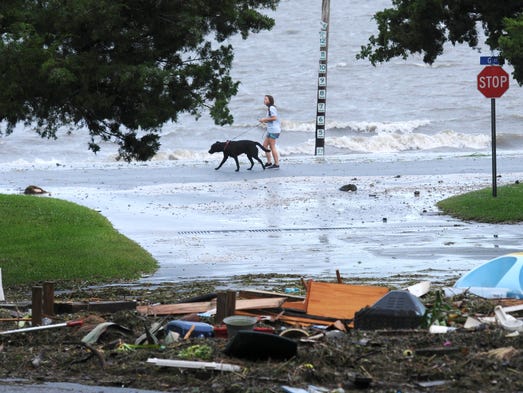 A woman walks her dog along the waterfront after Hurricane