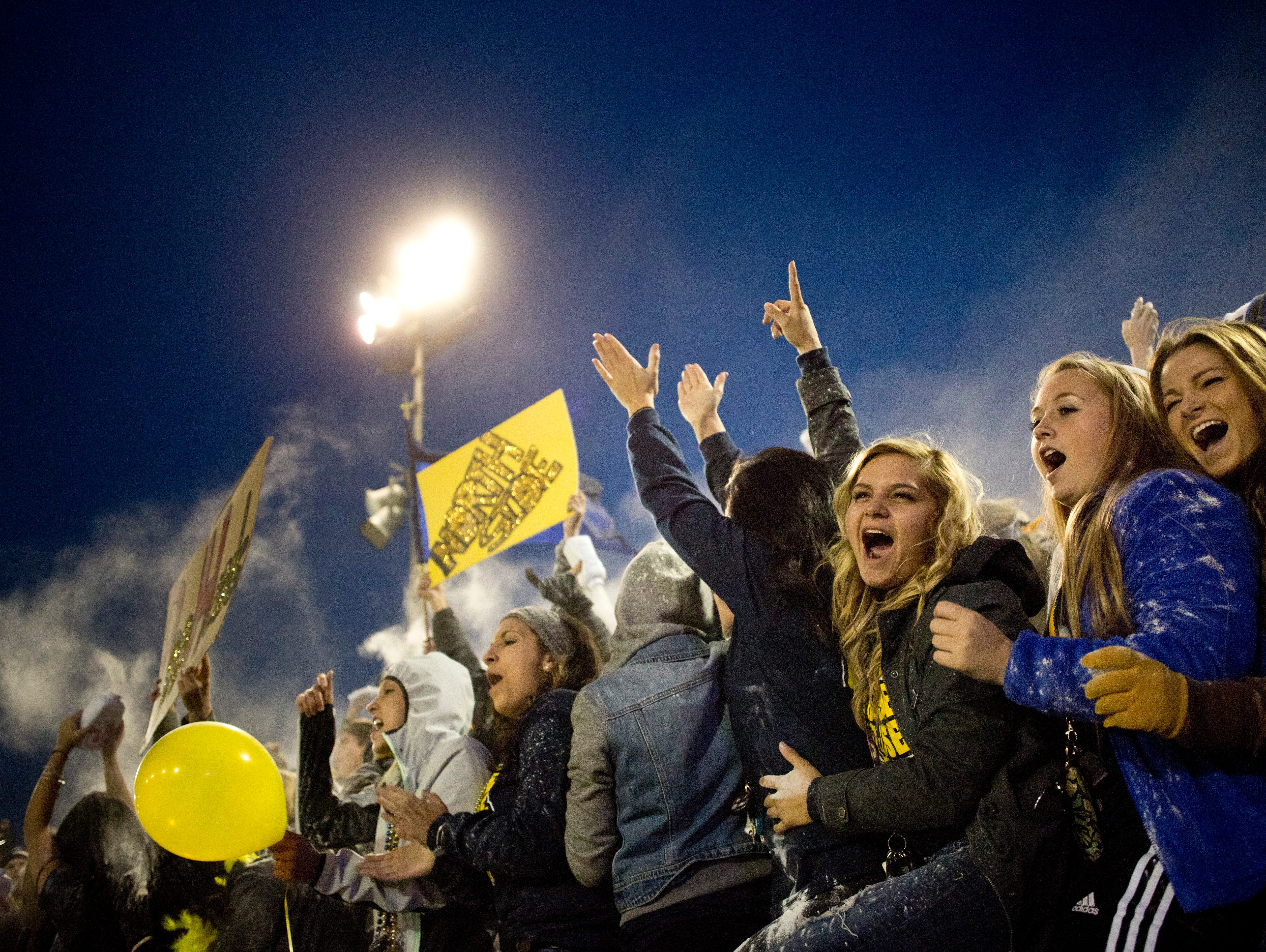 Port Huron Northern students cheer and throw baby powder in the air as the team takes the field during the Crosstown Showdown Friday, October 23, 2015 at Memorial Stadium in Port Huron.
