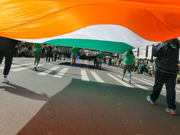 A large Irish flag is carried during the St. Patrick's