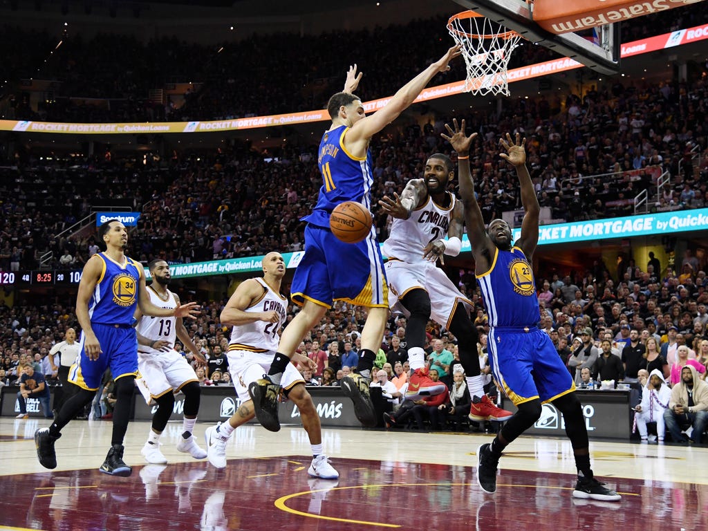 The Cleveland Cavaliers' Kyrie Irving passes the ball away from the Golden State Warriors' Draymond Green and Klay Thompson during the Cavaliers' 137-116 win in Game 4 of the NBA Finals in Cleveland.