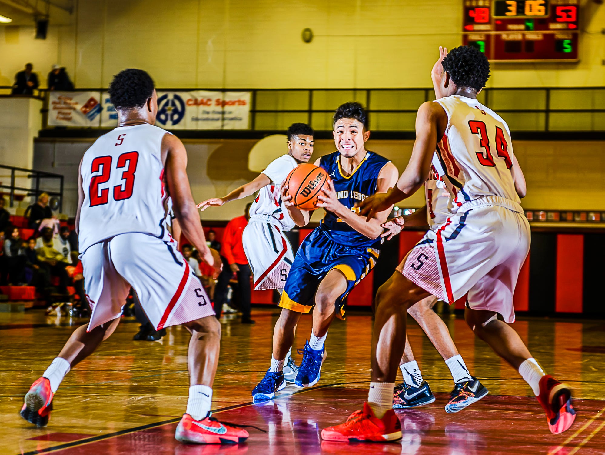 Malek Adams ,center, of Grand Ledge cuts through the Sexton defense on his way to the basket.