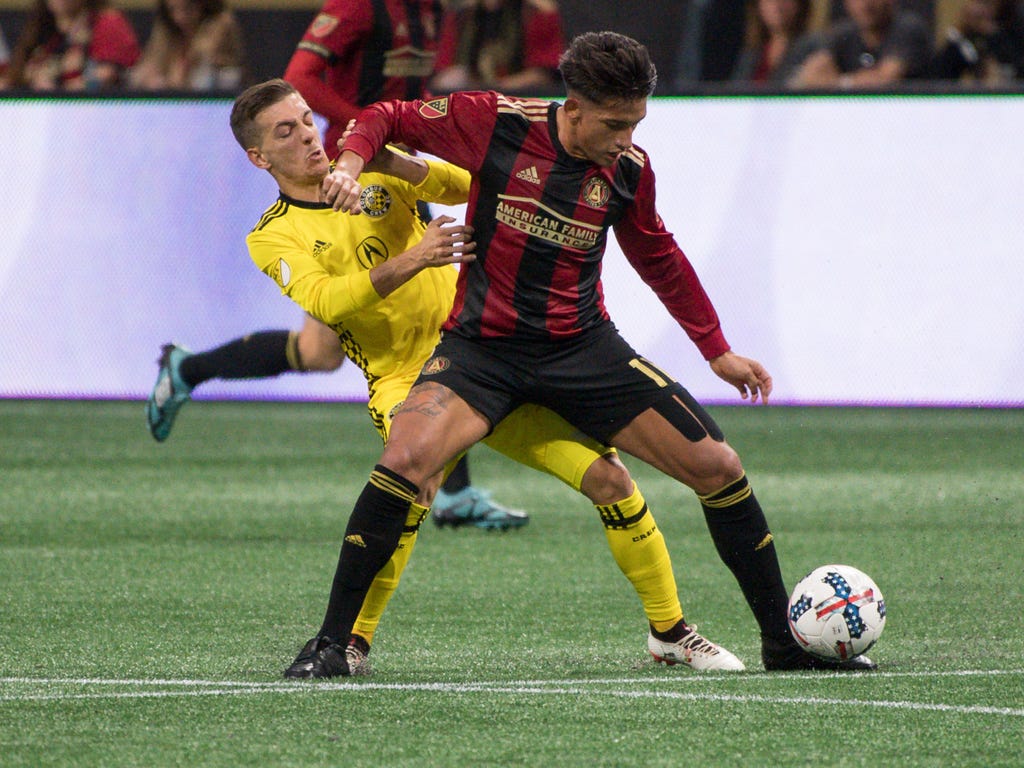 Atlanta United midfielder Yamil Asad, right, and Columbus Crew forward Pedro Santos fight for the ball during the first half during a Eastern Conference knockout round soccer game at Mercedes-Benz Stadium in Atlanta.