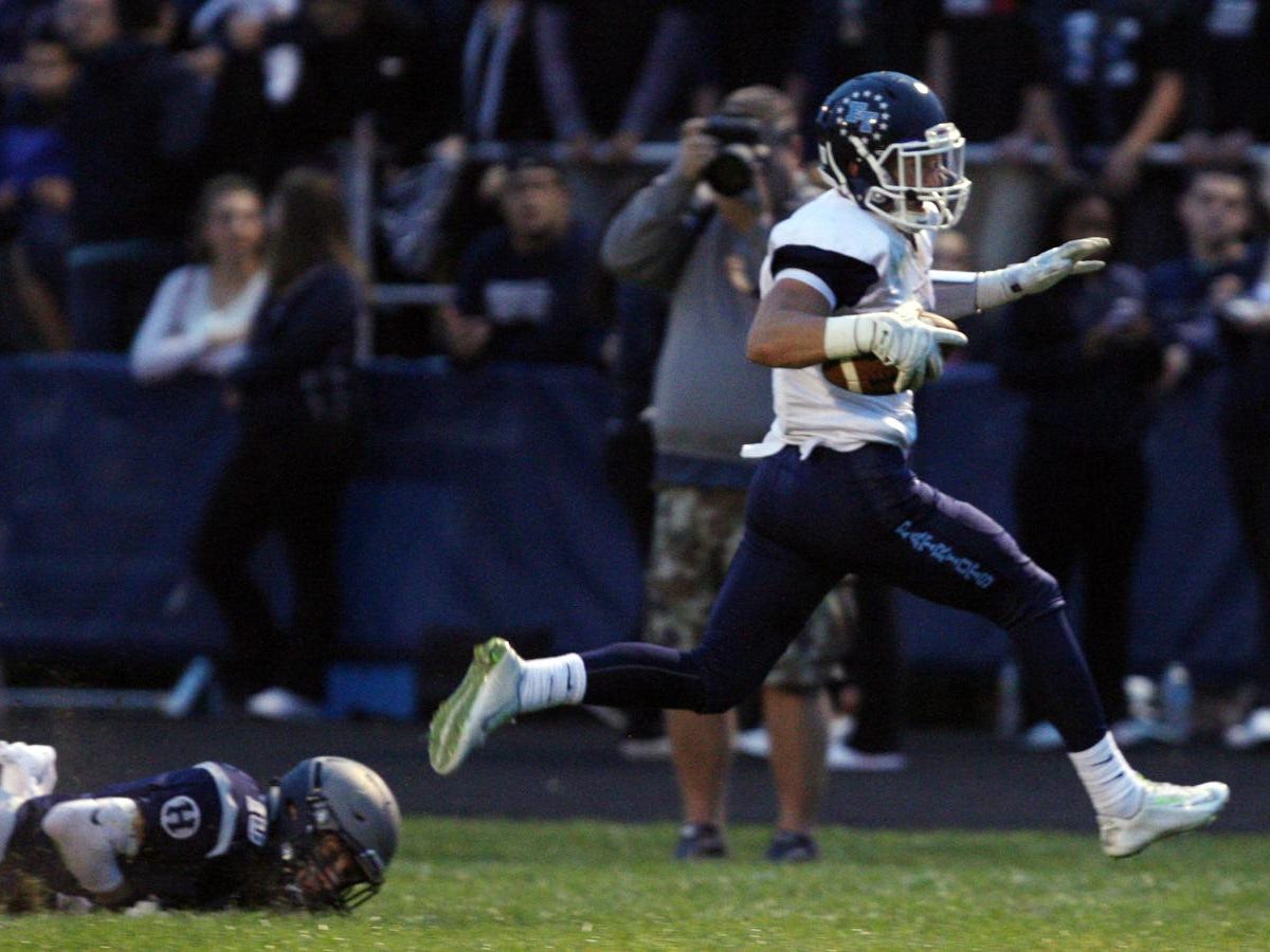 Adrian Rybaltowski, #4 Freehold Township, breaks free of Nic Rossi, #10 Howell, on his way to scoring a touchdown in a football game Friday, September 25, 2015, at Howell High School.