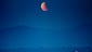 epa04437056 The moon is seen glowing red as its rise