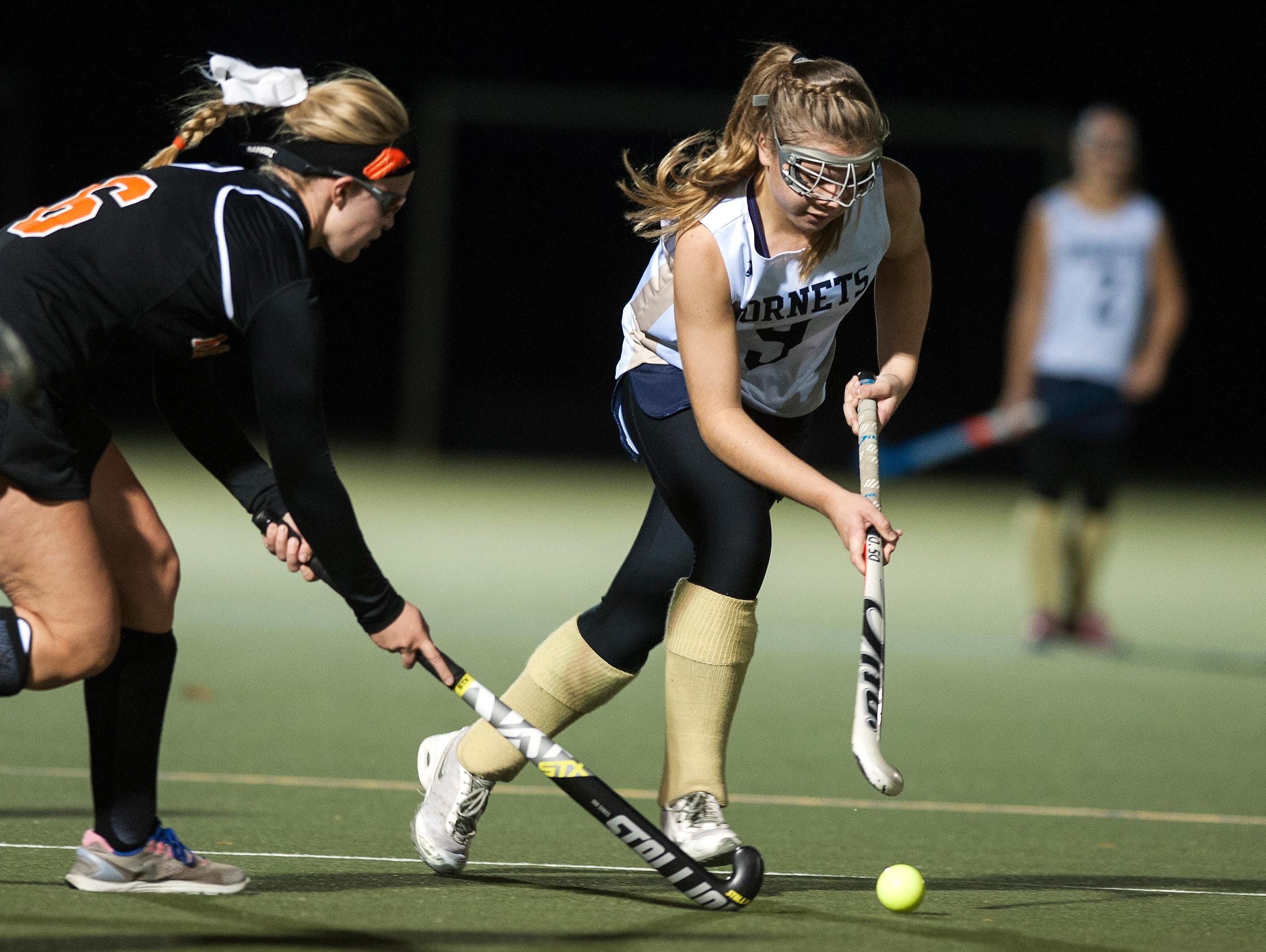 Essex's Kathleen Young (9) runs past Middlebury's Emma Snyder-White (6) with the ball during the girls semi final field hockey game between Middlebury and Essex at Middlebury College in October.