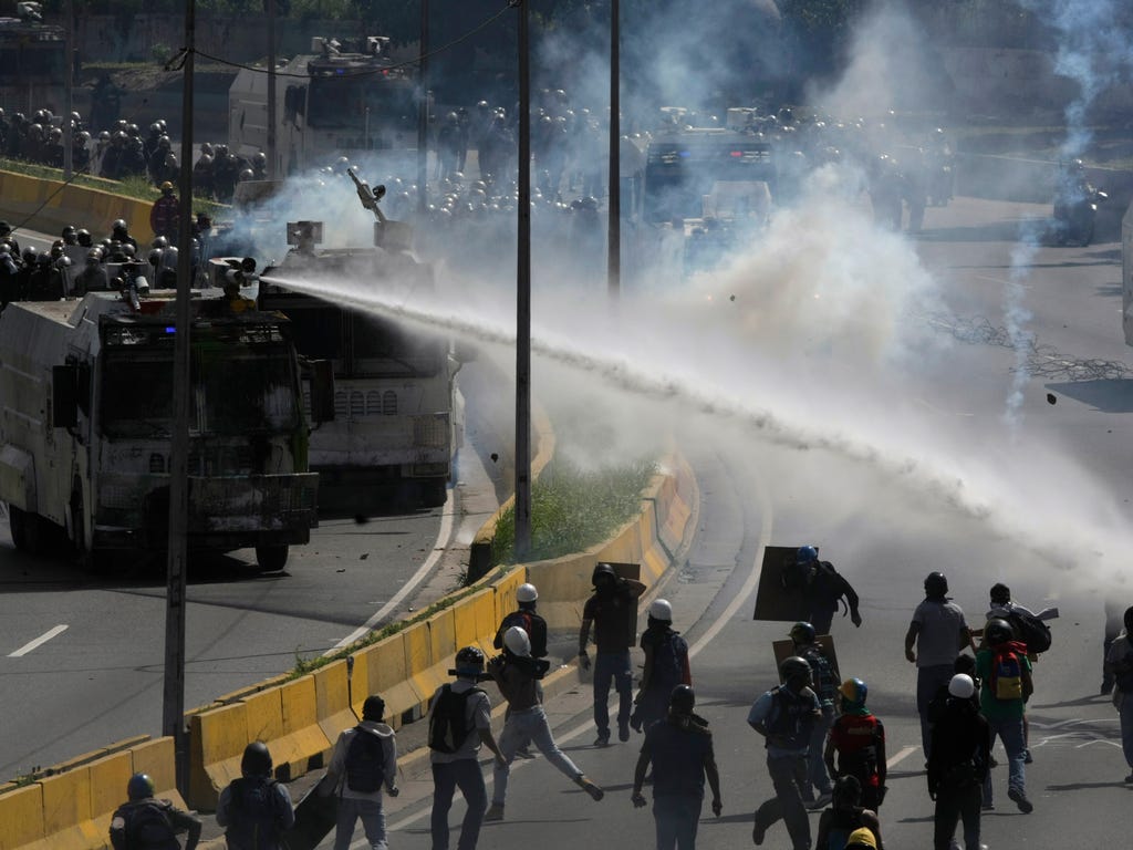 A water canon sprays government protesters trying to reach the Interior Ministry, in Caracas, Venezuela on May 18, 2017. The protest in Caracas comes after a tumultuous 24 hours of looting and protests in the western state of Tachira that led the gov