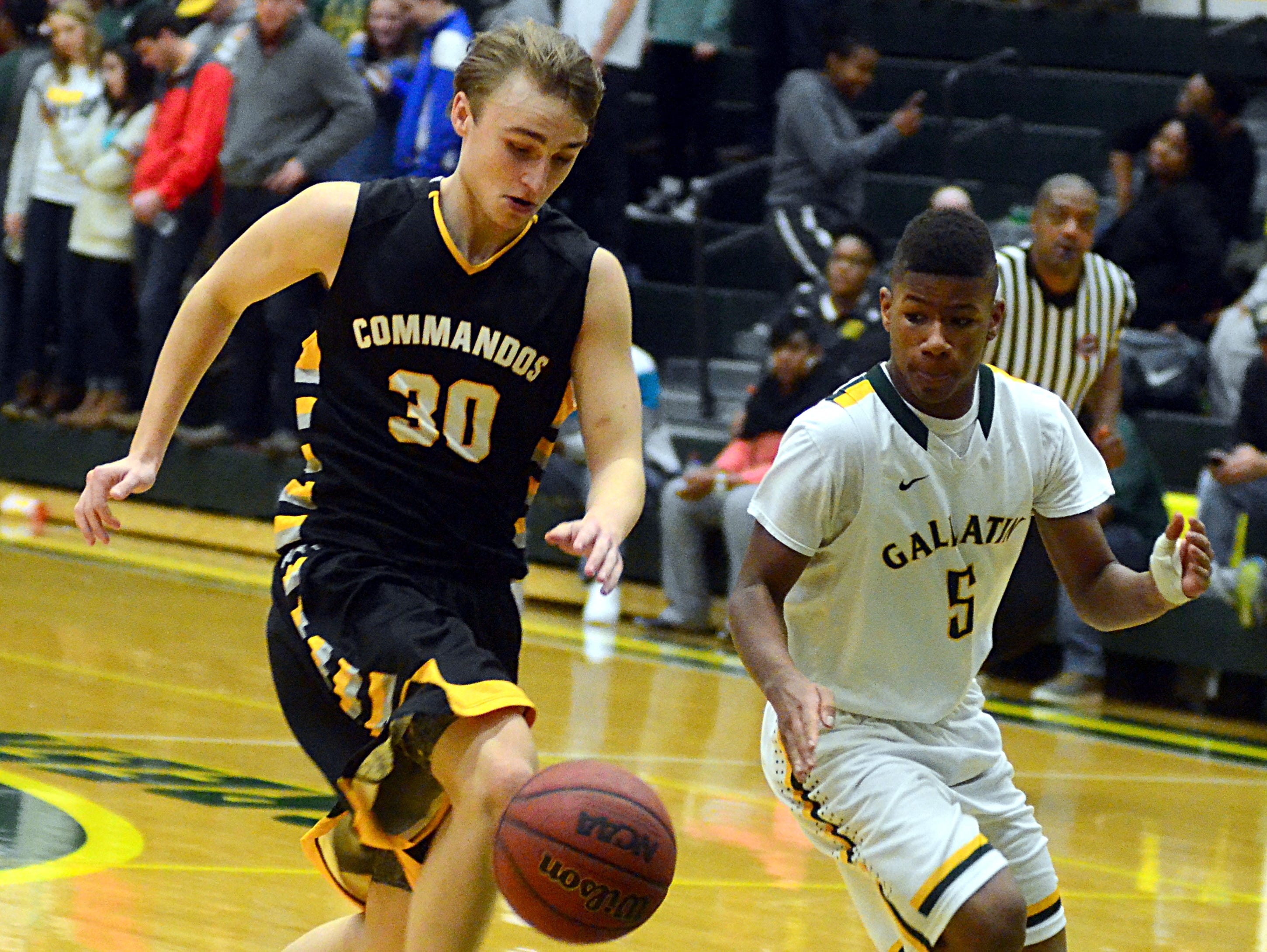 Hendersonville High junior guard Ryne Loper and Gallatin sophomore guard Nigel Black pursue a loose ball during third-quarter action.