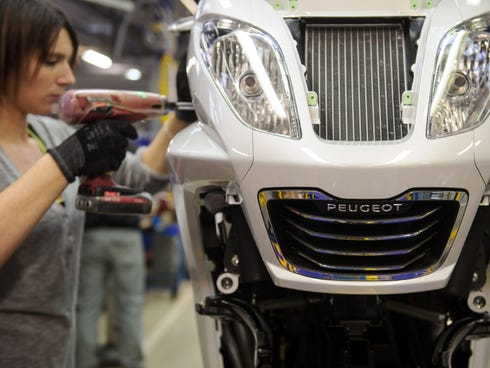 An employee works on the production line of the Peugeot Metropolis motorcycle series by French car and motorcycle maker PSA Peugeot Citroen