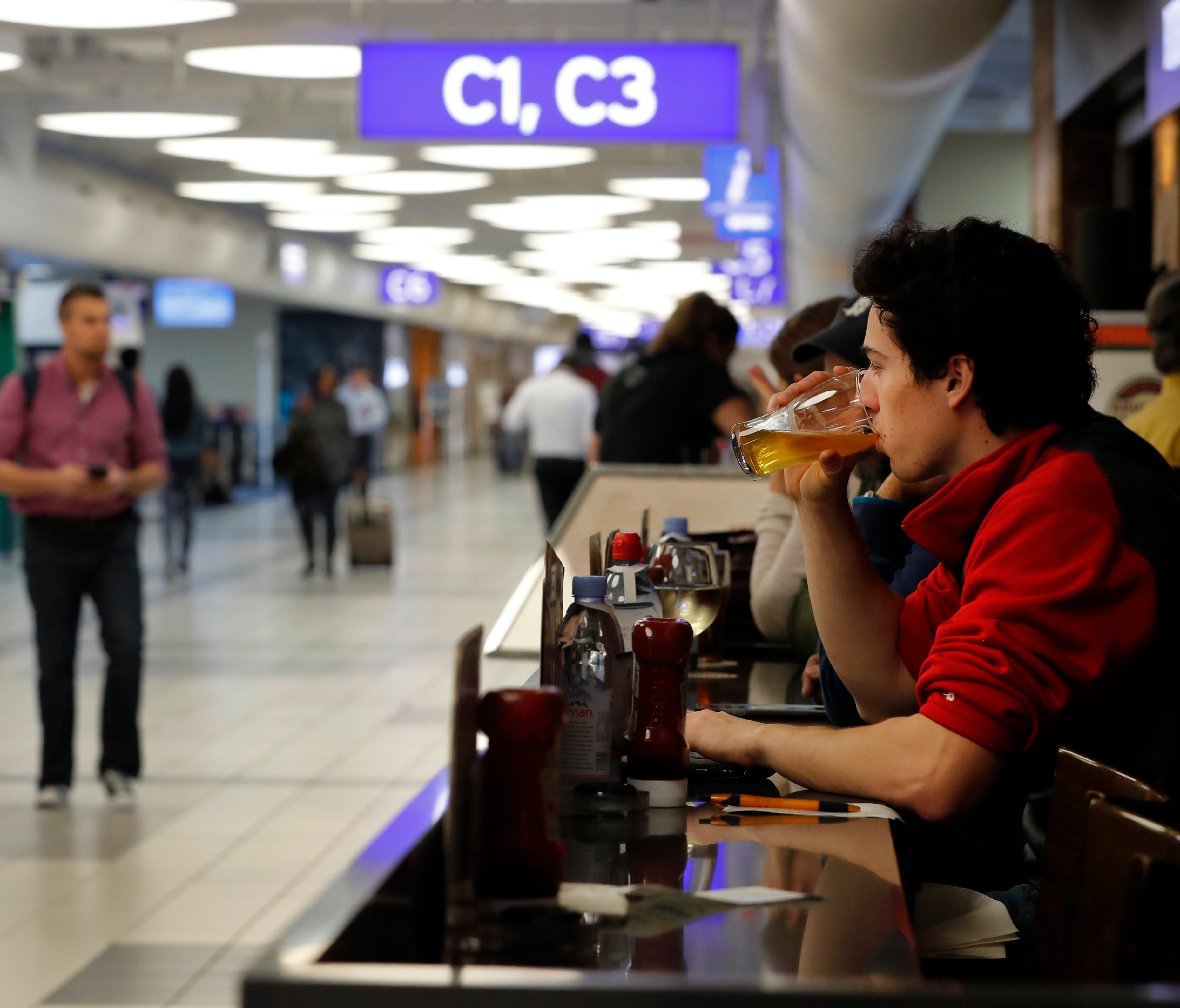 In this photo from Feb. 24, 2017, traveler Dominic Maley sips on a beer while waiting to board a flight at St. Louis Lambert International Airport.
