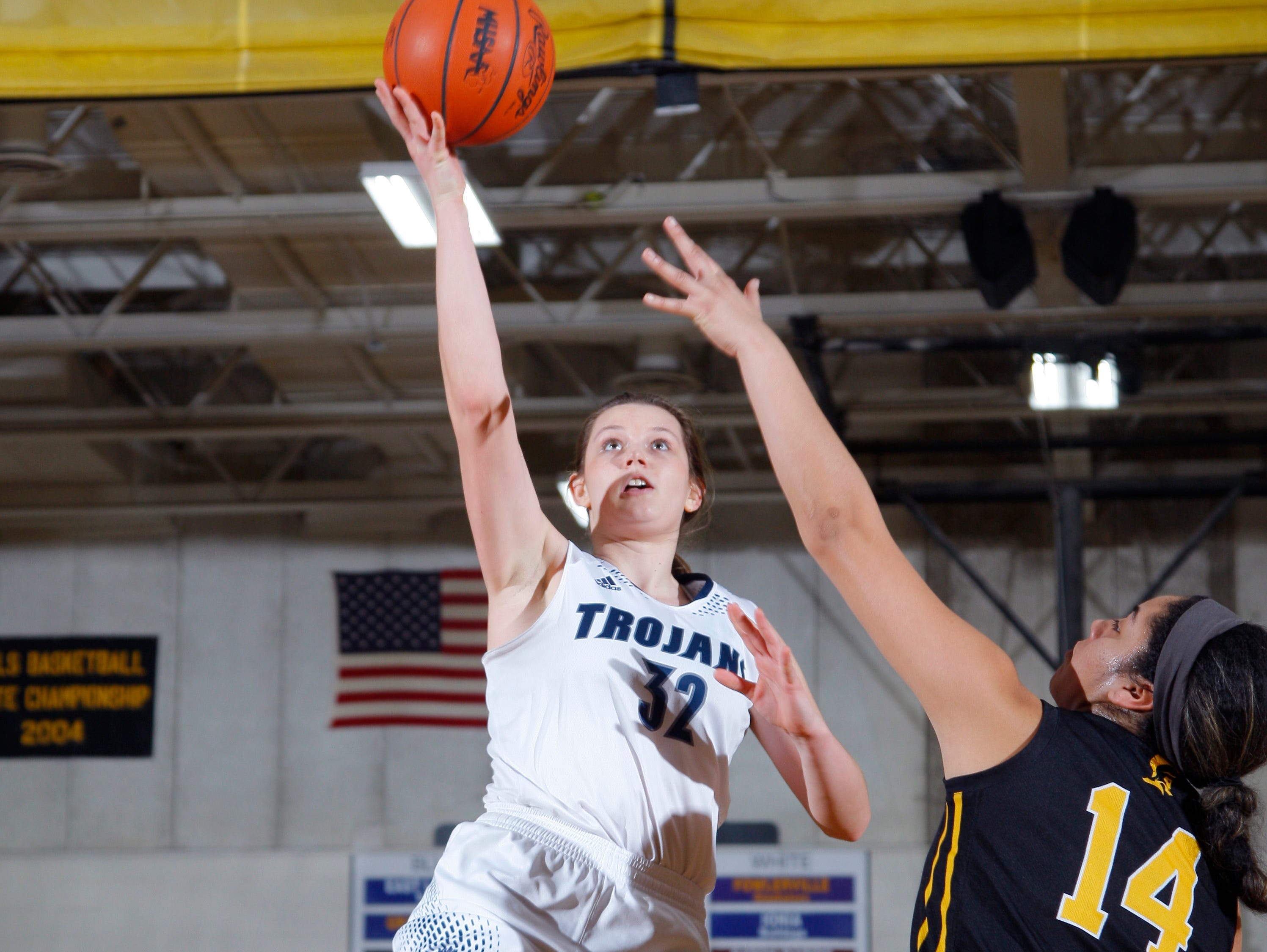 East Lansing's Danni Hanson, left, puts up a layup against Waverly's Mikailah Jackson Friday, March 4, 2016, at Waverly High School. East Lansing won 57-41 to take the District title.