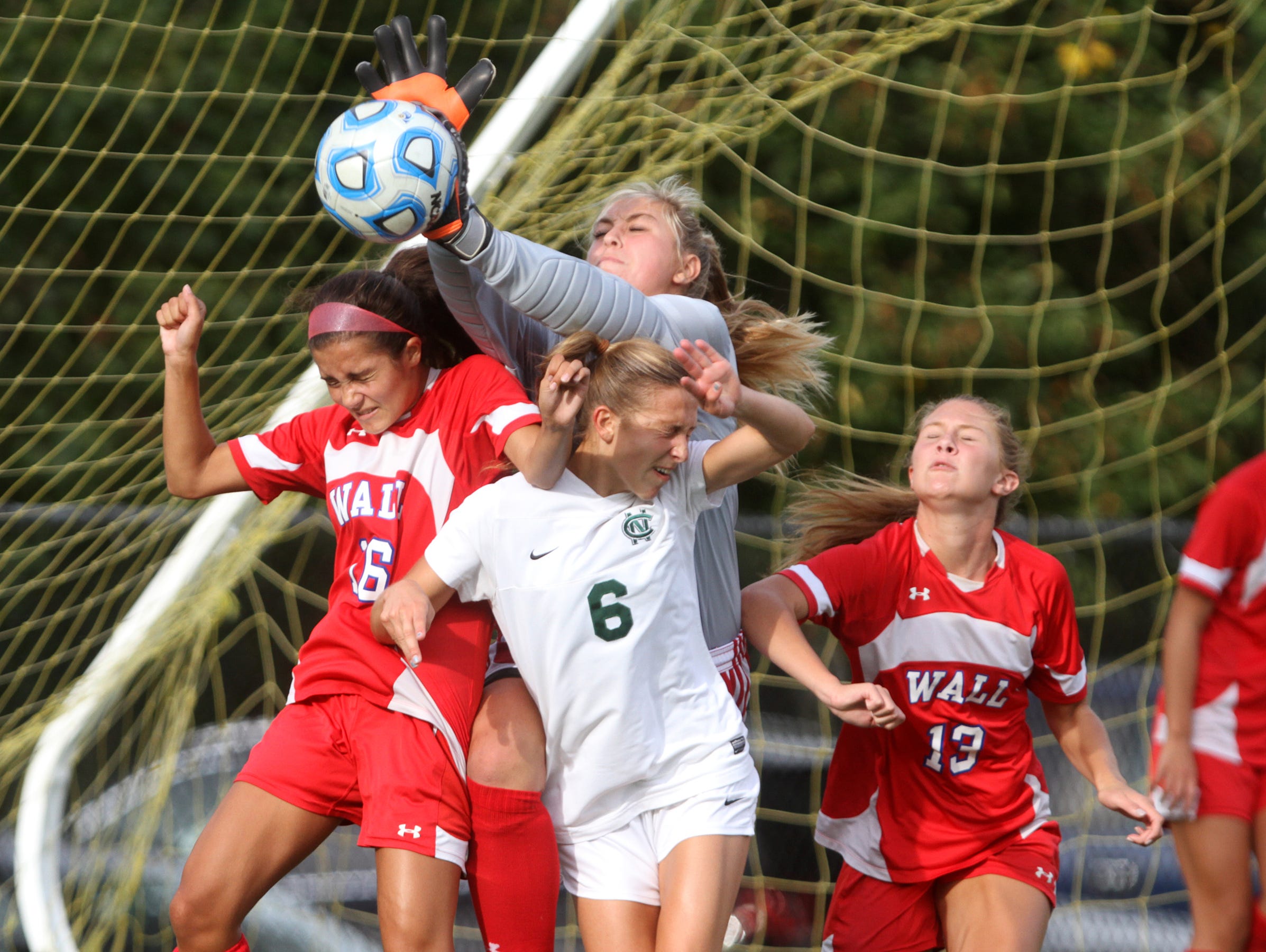 Wall goalie Alex Panasuk and teammates Kelsey Nies (16) and Jamie Iorio (13) defend a first-half corner kick intended for Colts Neck's Allison Russo (6), Wednesday, September 30, 2015, in Marlboro, NJ