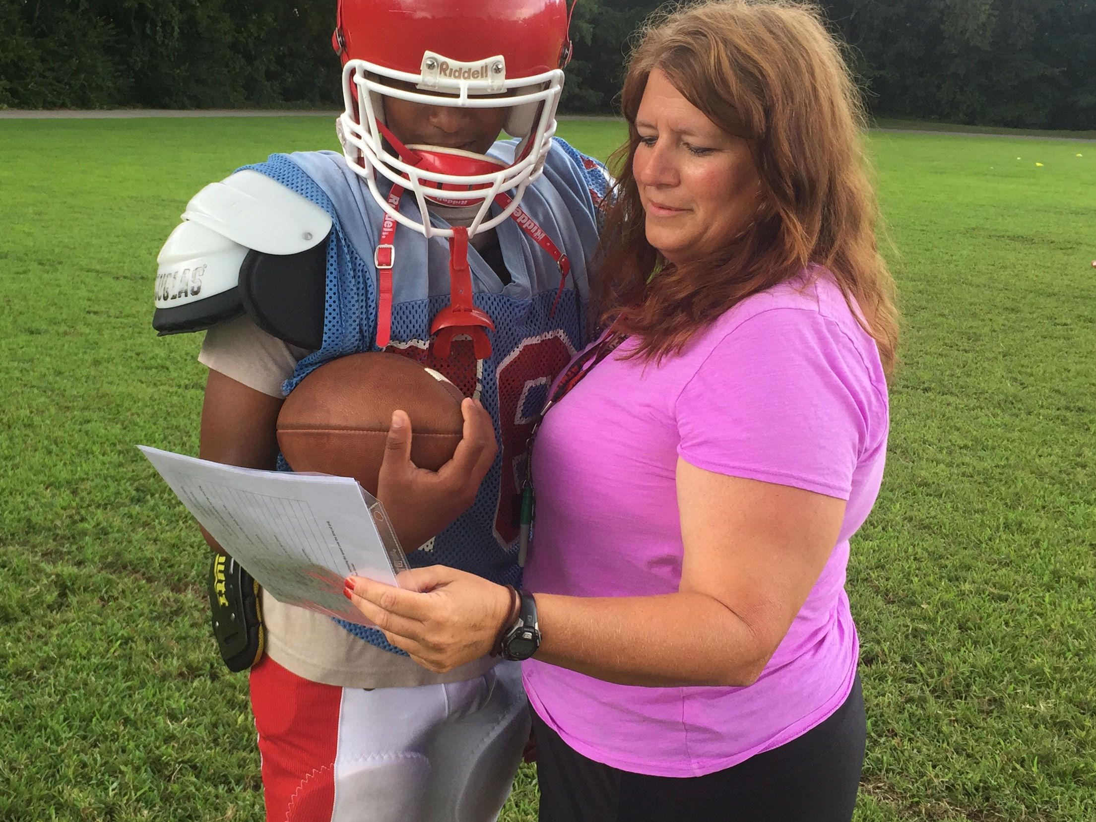 Glencliff quarterback Varon Solano consults with Colts assistant coach Lisa Limper.