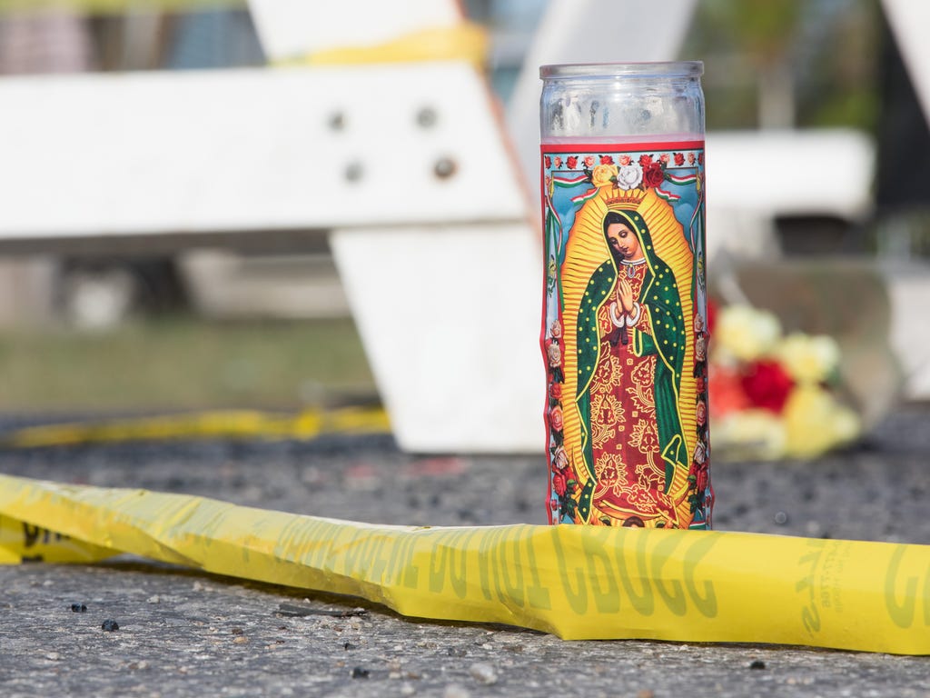 A prayer candle tangled in crime scene tap sits at the roadblock leading to the First Baptist Church in Sutherland Springs, Texas on Nov. 6, 2017, the day after a shooting that left 26 dead.