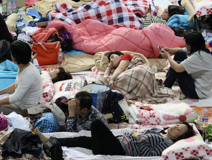 Parents whose children were aboard the Sewol ferry and are now missing rest on the floor at a gymnasium in Jindo, South Korea on April 18, 2014. The captain of the doomed ferry delayed evacuation for half an hour after a South Korean transportation official ordered preparations to abandon ship, raising more questions about whether quick action could have saved lives.