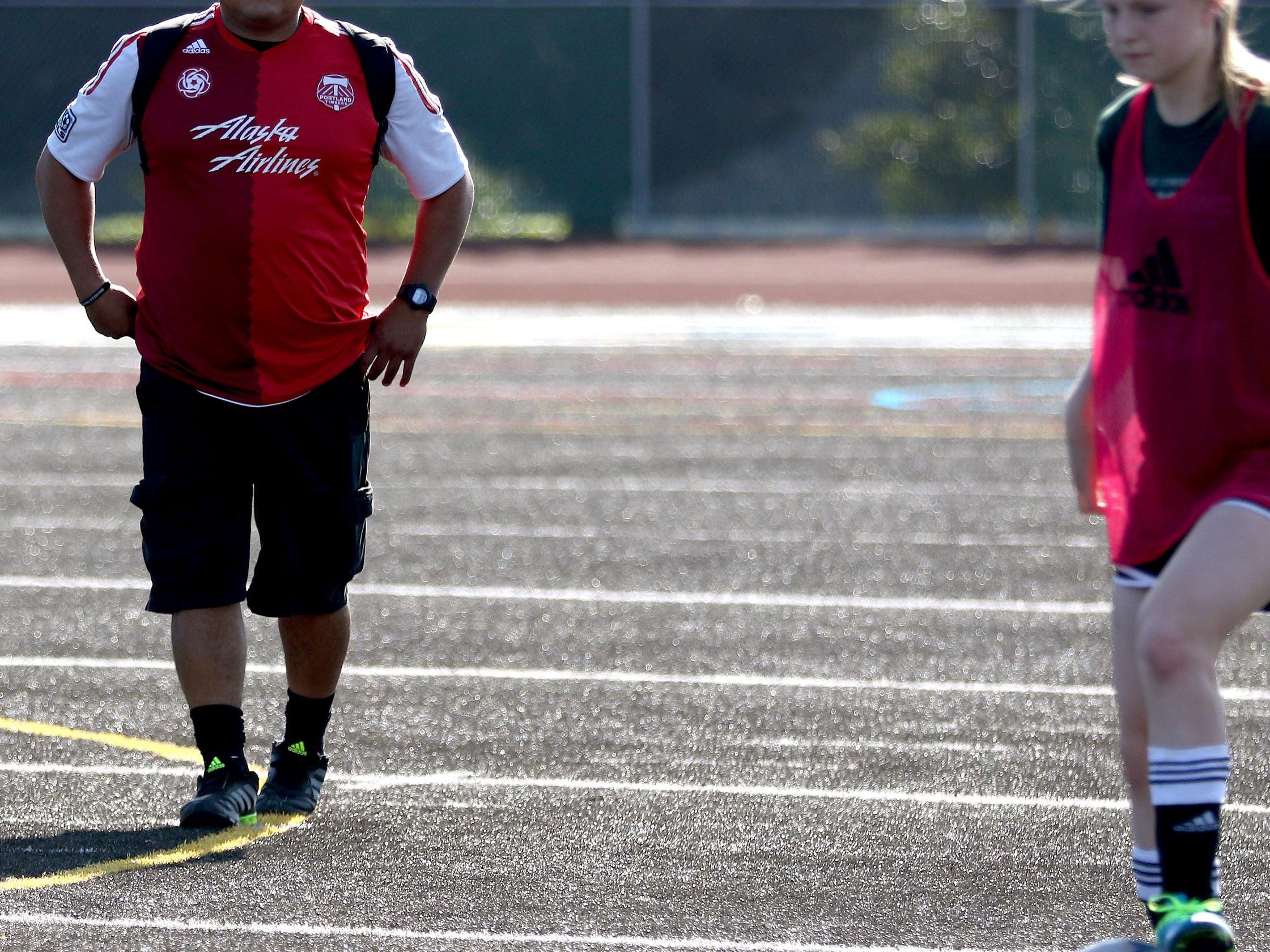 Head coach Jaime Rodriguez watches his players during girl's soccer practice at West Salem High School on Thursday, Aug. 27, 2015.