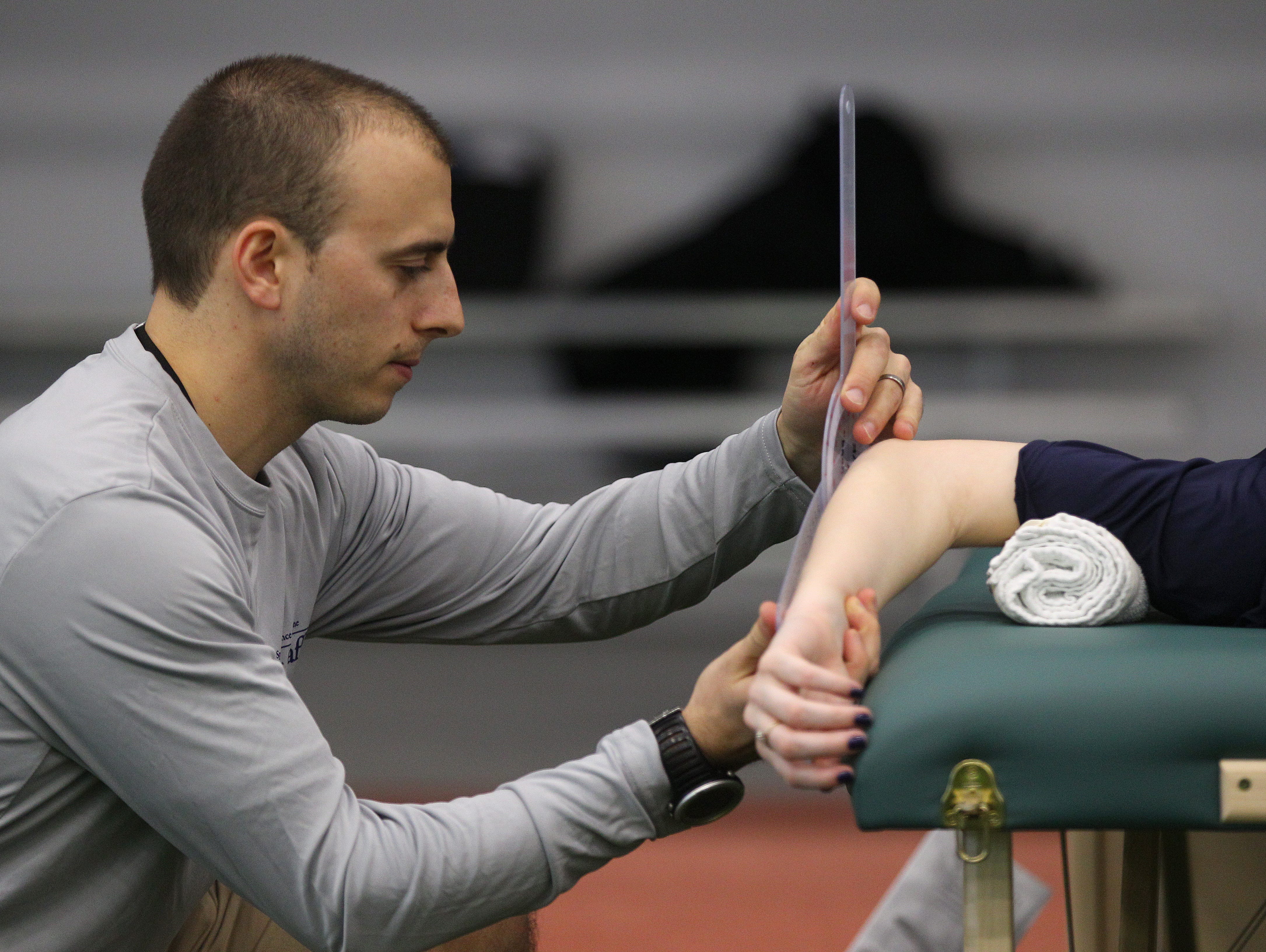 Jeremy Peters, a physical therapist with UR Medicine measures the range of motion of an athlete during the AGR Sports Combine.