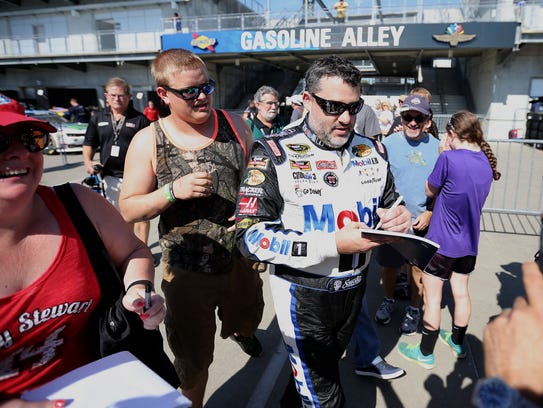 Tony Stewart signs autographs for fans following the