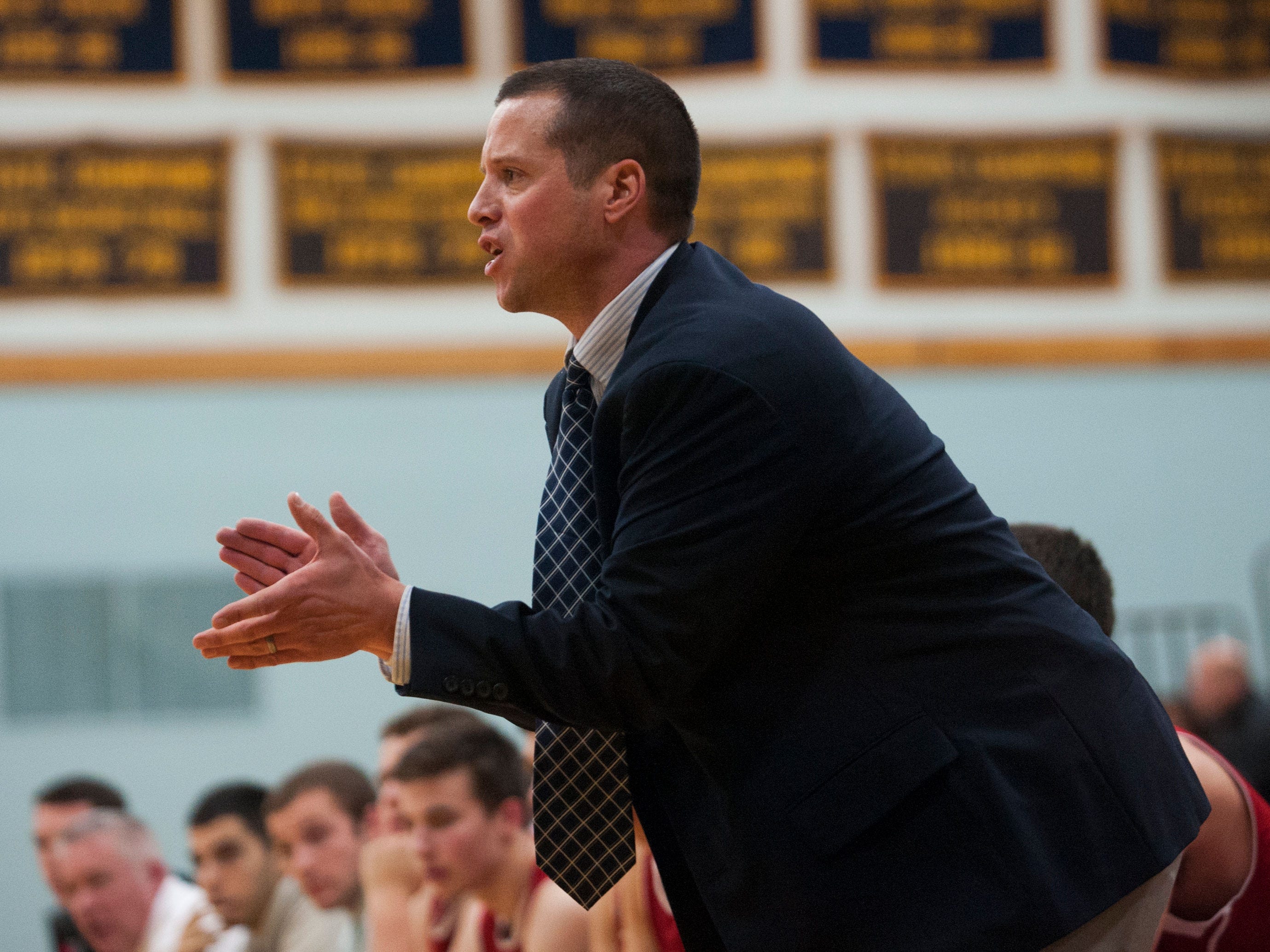 CVU head coach Michael Osborne cheers for his team during the boys basketball game between the Champlain Valley Union Redhawks and the Essex Hornets on Friday night.