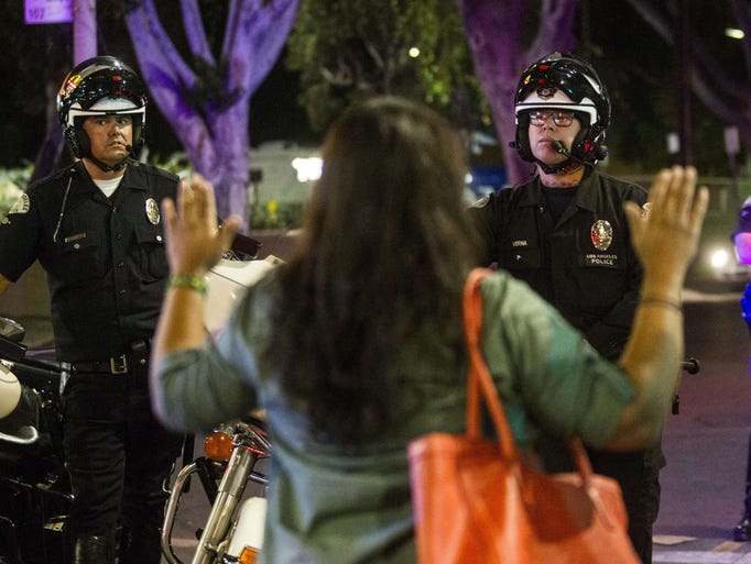 A demonstrator raises her hands in front of police
