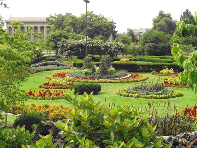 The park features gardens, a pond and running loop, art and music events, and a large lawn.