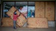 A worker removes plywood from shop windows after the