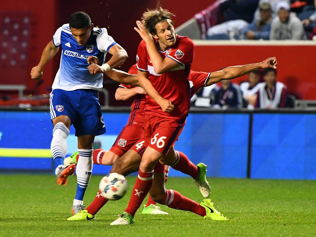 FC Dallas forward Cristian Colman  kicks the ball against Chicago Fire defender Joao Meira at Toyota Park. Chicago won the game, 2-1, for its fourth consecutive win.