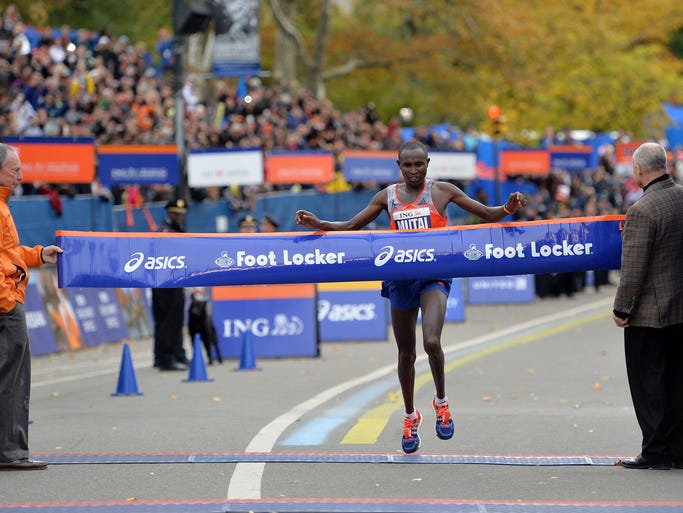 Geoffrey Mutai of Kenya crosses the finish line to win the men's division of the New York City Marathon.