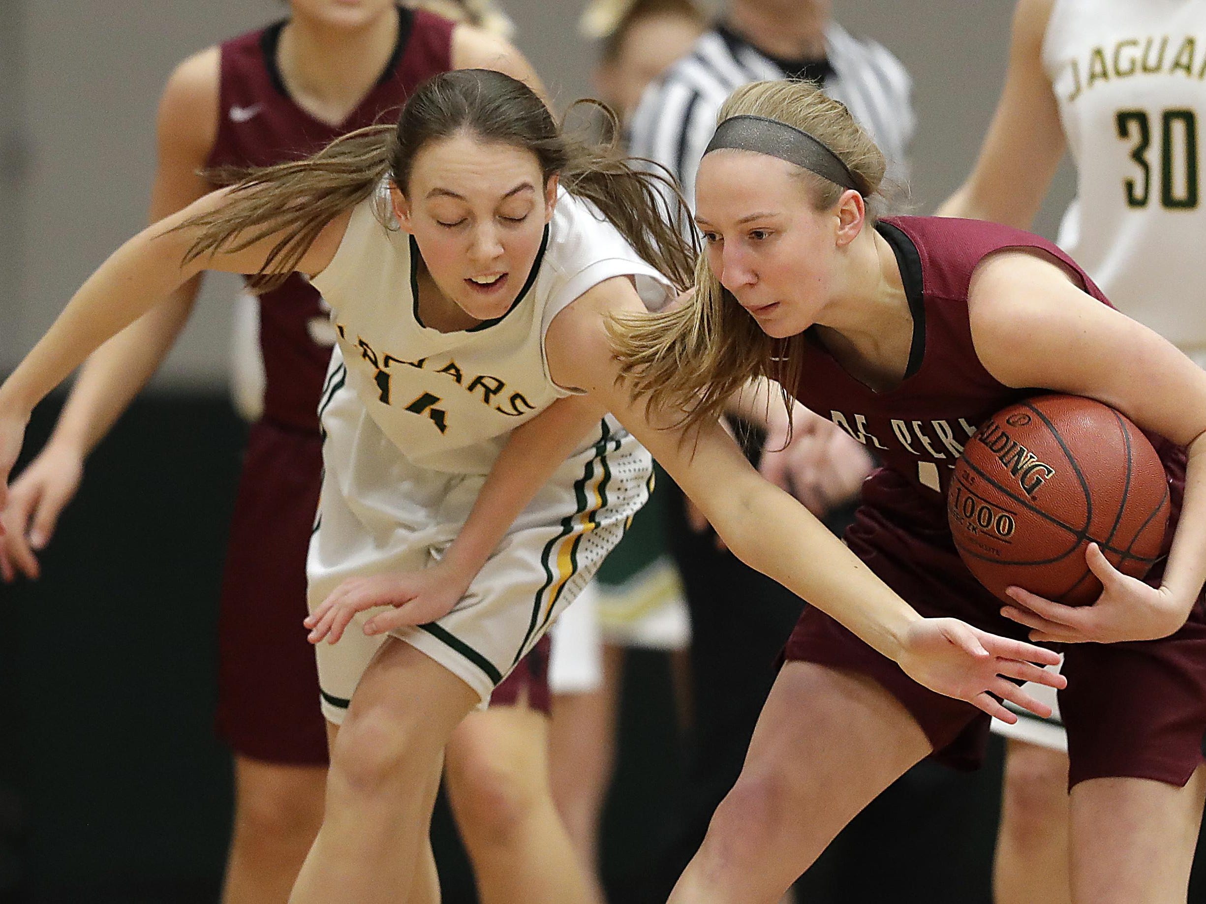 Ashwaubenon’s Megan Servais reaches for a steal attempt on De Pere’s Lizzie Miller on Thursday.