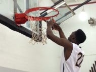 Javan Thomas (No. 22) takes his turn cutting down the basketball net after Schoolcraft College’s men’s basketball team won the MCCAA title Saturday.
